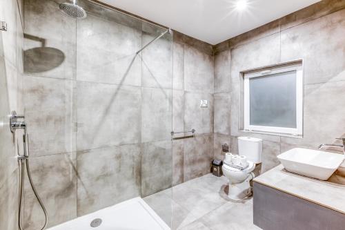 a bathroom with a shower and a toilet and a sink at Modern Paceville Suites with WIFI & AC by 360 Estates in Paceville