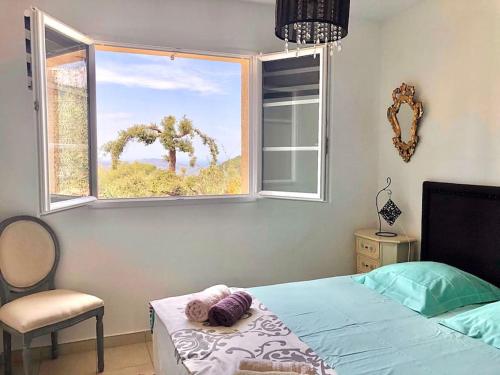 une chambre avec un lit et une grande fenêtre dans l'établissement A CasaLèna - Maison individuelle Balagne, à Urtaca