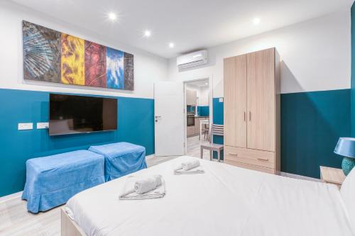 a bedroom with two beds and a blue wall at Modern Paceville Suites with WIFI & AC by 360 Estates in Paceville