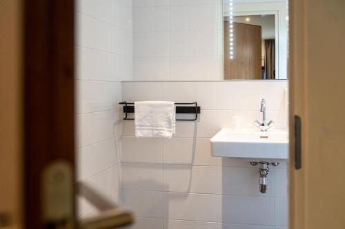 a white bathroom with a sink and a mirror at De Johanneshoeve in Westerhaar-Vriezenveensewijk