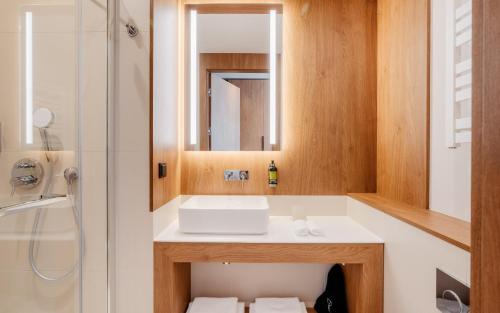 a bathroom with a sink and a shower at Hotel Pieniny Grand Wellness & SPA - Destigo Hotels in Szczawnica