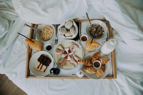 uma bandeja cheia com diferentes tipos de comida numa cama em Colors Hotel Athens em Atenas