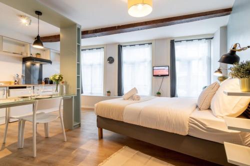 une chambre avec un grand lit et une cuisine dans l'établissement Lille Hypercentre / Gares - Superbe studio équipé, à Lille