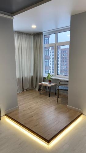 a living room with a table and a large window at FlatService Просторі апартаменти в сучасному ЖК Parkland in Kyiv