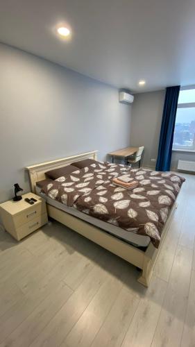 a bedroom with a bed and a table and a window at FlatService Просторі апартаменти в сучасному ЖК Parkland in Kyiv