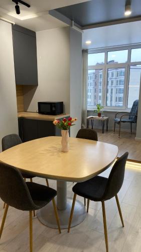 a table in a room with chairs and a kitchen at FlatService Просторі апартаменти в сучасному ЖК Parkland in Kyiv