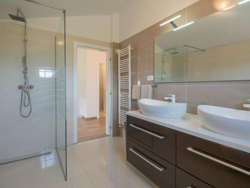a bathroom with two sinks and a glass shower at Villa Drazana in Imotski