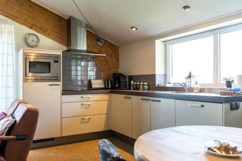 a kitchen with a table and a microwave at De Johanneshoeve in Westerhaar-Vriezenveensewijk