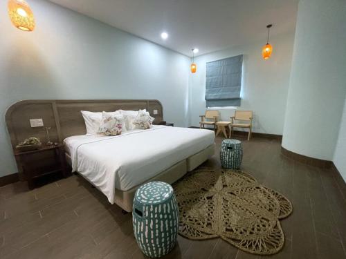 a bedroom with a bed and a table and chairs at Aurora Phu Quoc Hotel & Golf 3D in Phu Quoc