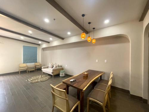 a living room with a table and chairs and a couch at Aurora Phu Quoc Hotel & Golf 3D in Phu Quoc