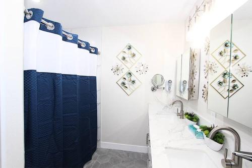 een badkamer met een douche en een blauw douchegordijn bij NEW! 2-Bedroom Fontana Guest House near Speedway in Fontana