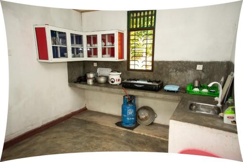 a kitchen with red and white cabinets and a sink at Mango villa in Unawatuna