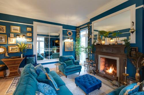a blue living room with a blue couch and a fireplace at The Georgian Villa in Ross on Wye
