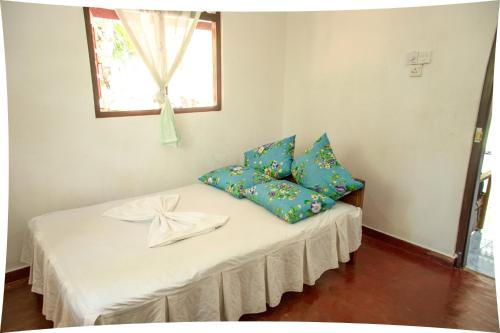 Habitación con cama con almohadas azules. en Mango villa, en Unawatuna