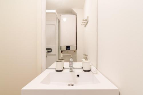 y baño con lavabo blanco y espejo. en Lille Centre - Nice and functional studio, en Lille