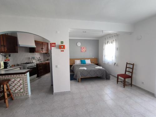 a kitchen and a bedroom with a bed in a room at Apartamentos Campos 1 in Porto Covo