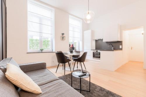 un salon blanc avec un canapé et une table dans l'établissement Nice apartment 2 bedrooms in Old Lille!, à Lille