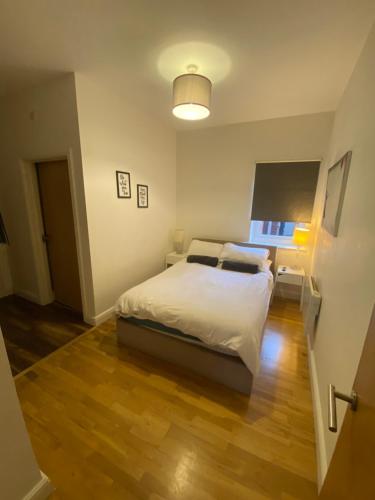 a bedroom with a white bed and a lamp at Midland Apartments- one bedroom in Leicester