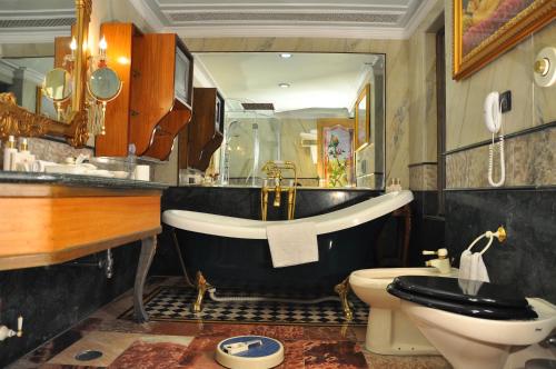 a bathroom with a tub and a toilet and a sink at Shiv Vilas Resort in Jaipur