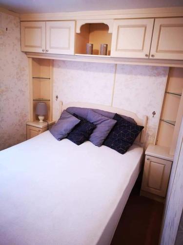 a bedroom with a white bed with two pillows on it at Domki pod mazurskim niebem in Pilchy