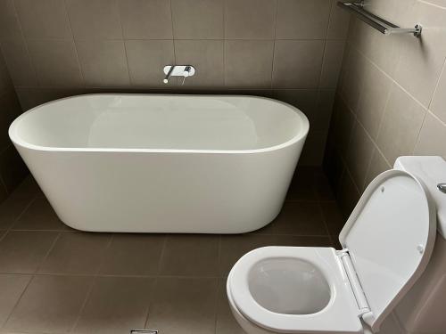 een badkamer met een bad en een toilet bij Affordable Semi rural stay in Annangrove