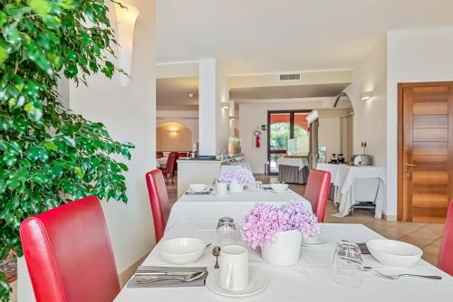 a dining room with white tables and red chairs at Park Hotel Argento in Levanto