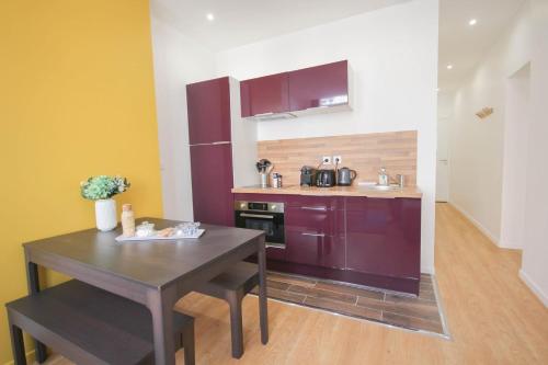 Una pequeña cocina con una mesa y un fregadero. en Superb apartment near the Grand Place!, en Lille