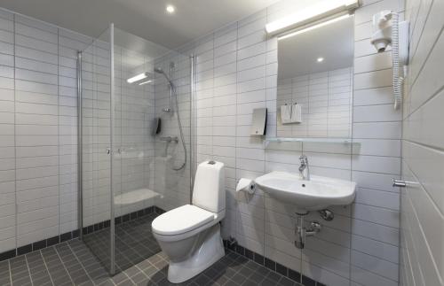 
a white toilet sitting in a bathroom next to a sink at Thon Hotel Trondheim in Trondheim
