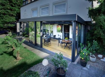 a house with a patio with a table and some plants at Hotel Burgblick in Badenweiler