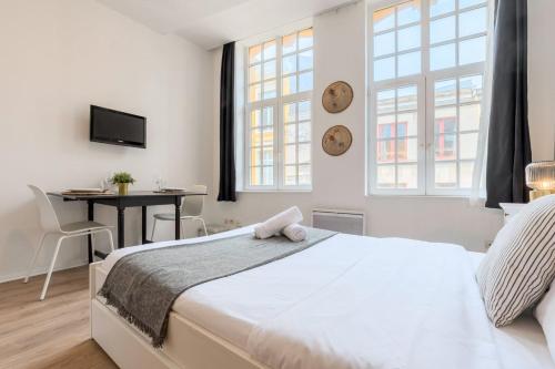 een witte slaapkamer met een bed en een bureau bij Lille Grand Place - Exceptional location ! in Lille