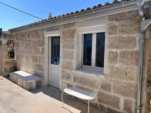 une chaise blanche assise devant un bâtiment dans l'établissement La Petite Grange - 5 mn gare SNCF - Wifi & Netflix, à Niort