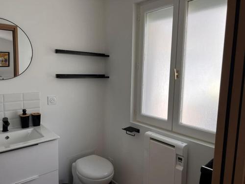 une salle de bain blanche avec toilettes et fenêtre dans l'établissement La Petite Grange - 5 mn gare SNCF - Wifi & Netflix, à Niort