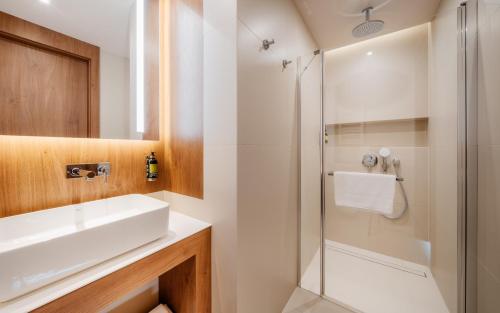 a bathroom with a sink and a shower at Hotel Pieniny Grand Wellness & SPA - Destigo Hotels in Szczawnica