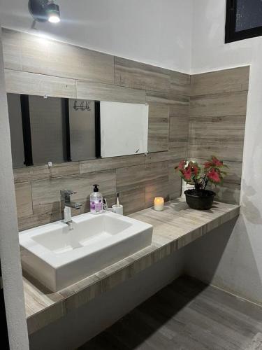 La salle de bains est pourvue d'un lavabo blanc et d'un miroir. dans l'établissement Casa Sac-Na, à Bacalar