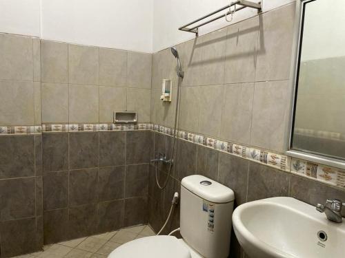 een badkamer met een toilet en een wastafel bij OYO 93467 Wisma Olo Syariah in Padang