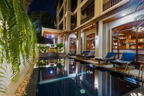 a hotel with a swimming pool in front of a building at Pierre Hotel in Siem Reap