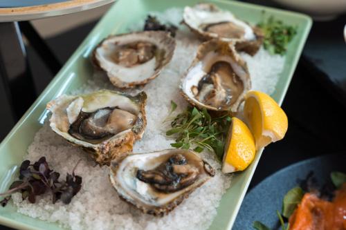 a green plate of oysters on top of rice at Hotel Kvarner - Liburnia in Opatija
