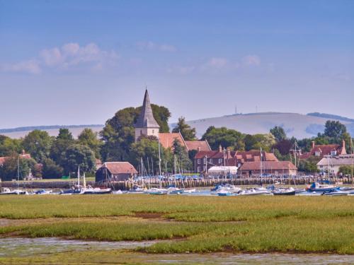 a group of boats in a harbor with a church at Pass the Keys Delightful Studio in West Ashling in Chichester