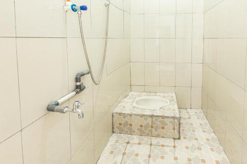 La salle de bains est pourvue d'une douche et de toilettes. dans l'établissement SPOT ON 93430 Delta Bnb Residence, à Perabumulih
