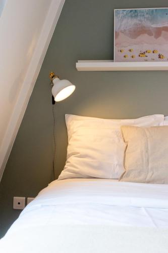 - une chambre avec un lit et une lampe sur le mur dans l'établissement Vieux Lille - Appartement idéal pour 2 personnes, à Lille
