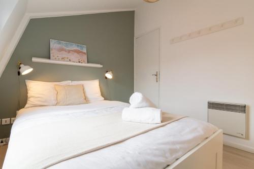 une chambre avec un grand lit avec des draps blancs dans l'établissement Vieux Lille - Appartement idéal pour 2 personnes, à Lille