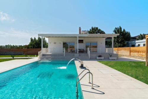 a swimming pool with a house in the background at Serenity Villas in Kolimbia