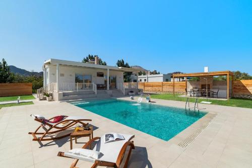 a villa with a swimming pool and a house at Serenity Villas in Kolimbia