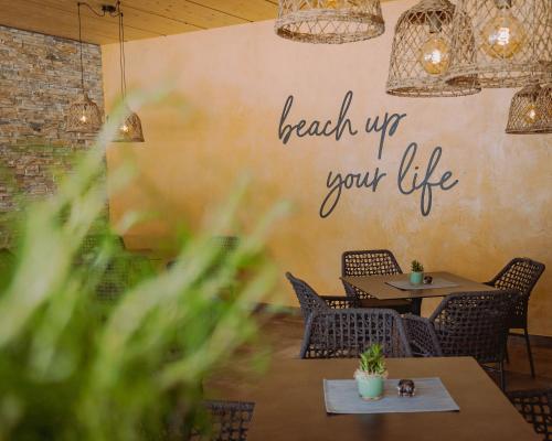 a restaurant with tables and chairs and a sign that reads reach up your life at Familienresort Buchau in Maurach