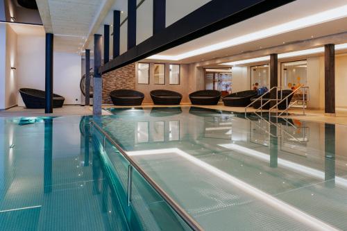 a large swimming pool with people sitting on chairs at Familienresort Buchau in Maurach