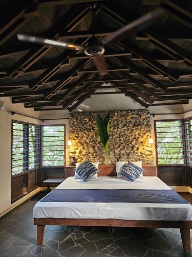 a bedroom with a large bed with a ceiling at Busua Beach House in Busua