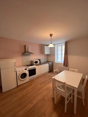 - une cuisine avec une table et une table et des chaises blanches dans l'établissement 