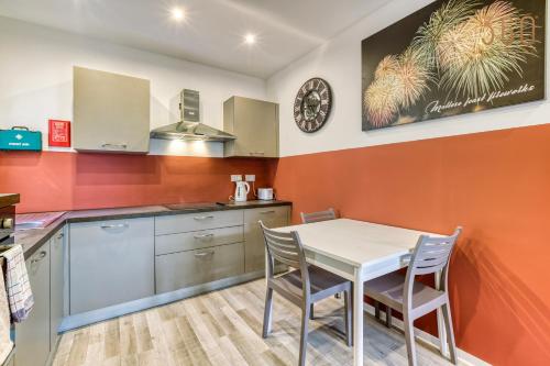 a kitchen with a table and chairs in it at Modern Paceville Suites with WIFI & AC by 360 Estates in Paceville