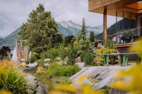 a garden with a house and mountains in the background at Familienresort Buchau in Maurach