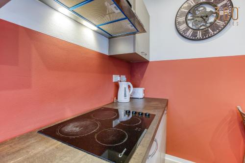 a kitchen with a stove and a clock on the wall at Modern Paceville Suites with WIFI & AC by 360 Estates in Paceville